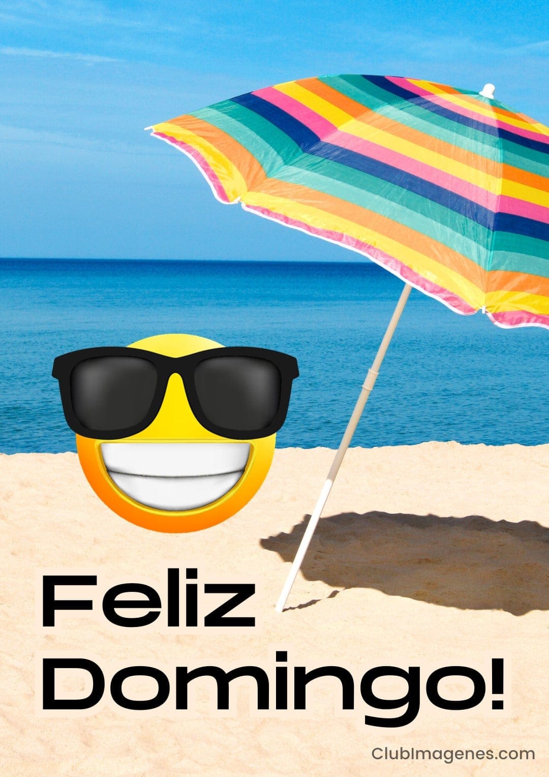 Sombrilla de colores, mar azul y emoticono con gafas de sol sobre arena con texto 'Feliz Domingo'